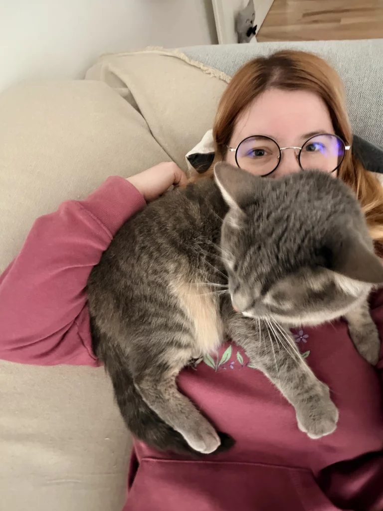 Graue Katze kuschelt auf Dianas Brust